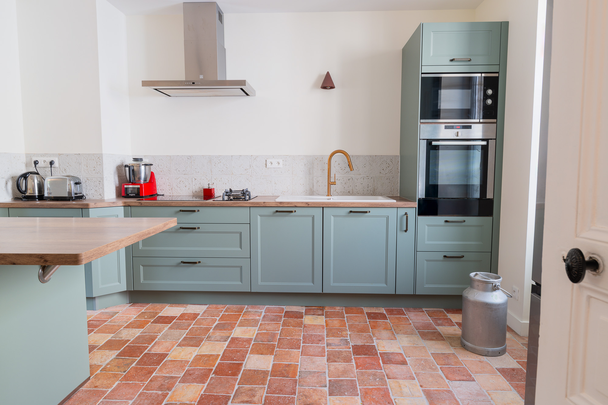 Cuisine verte rénovée avec hotte et plan de travail bois - conseil décoration après