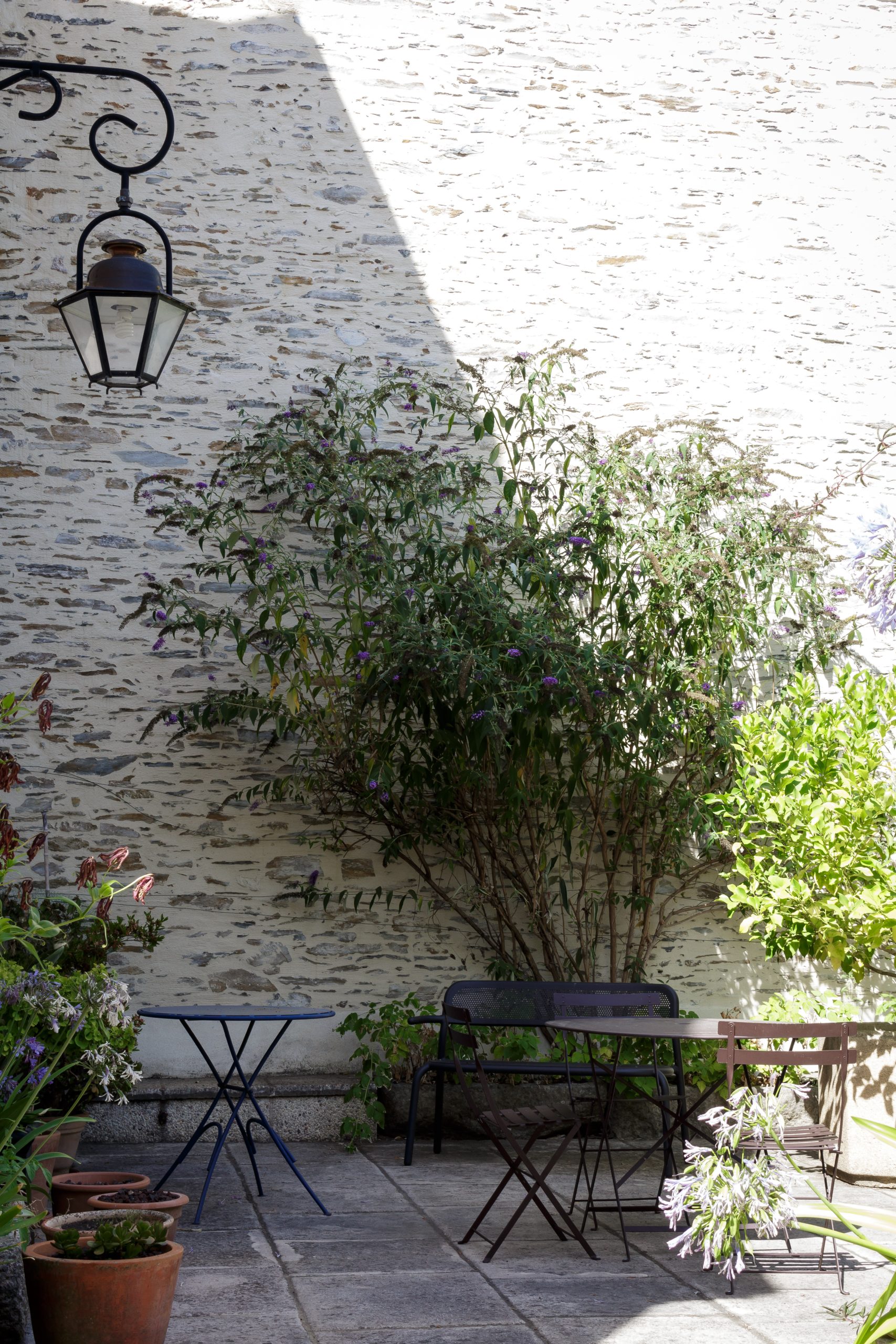 Cour intérieure en pierre avec mobilier de jardin et lanterne – Projet Doutre à Angers